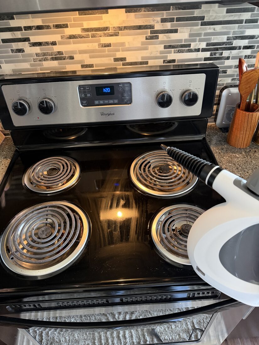 Customer cleaning stovetop coils with the Velmora steam cleaner